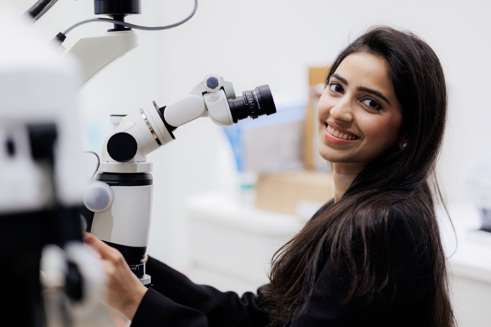 Dr. Esha Goel beside her dental operating microscope