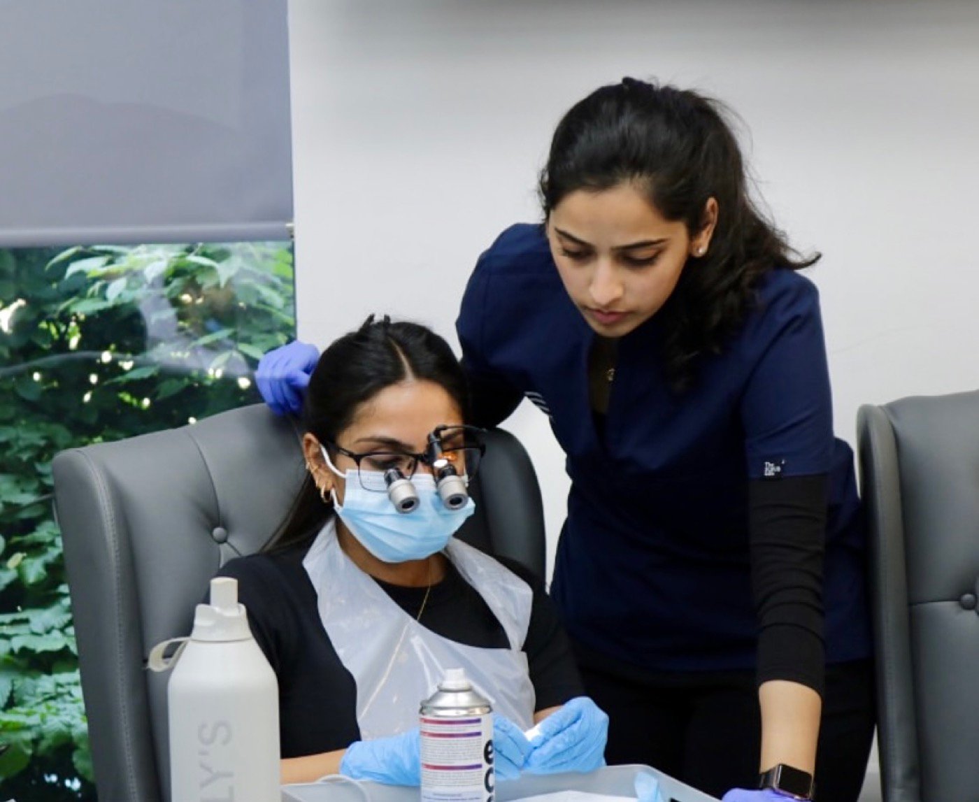 Dr. Goel guiding a delegate wearing loupes